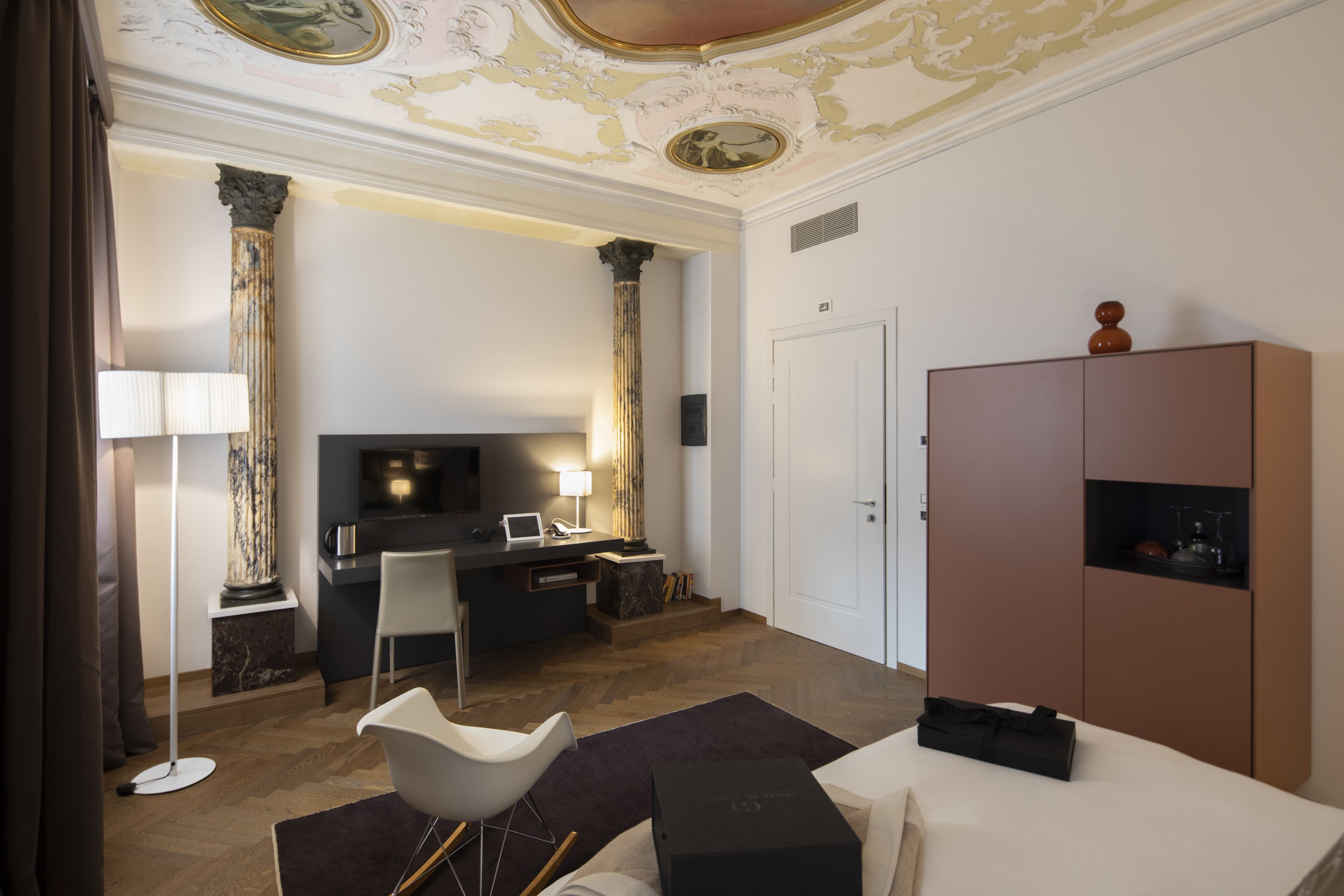Ett modernt hotellrum med ett skrivbord, en stol och en stor garderob.