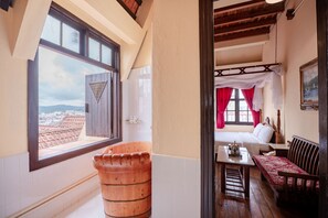 A room with a large window, a wooden bench, a bed with a canopy, and a painting on the wall. - Saphir Dalat Hotel (Da Lat)