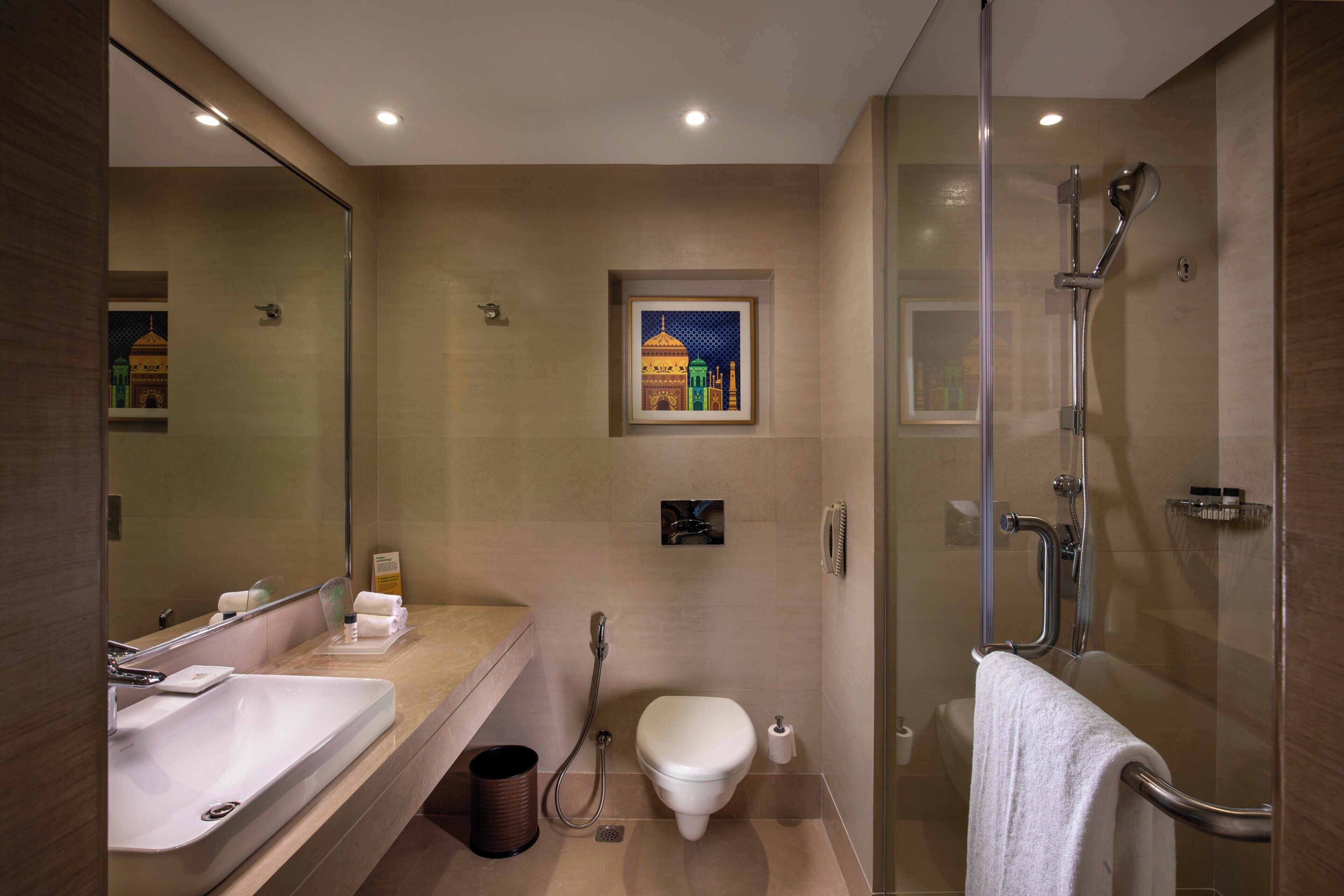 Une salle de bain moderne avec une douche à parois de verre, un lavabo et des toilettes.