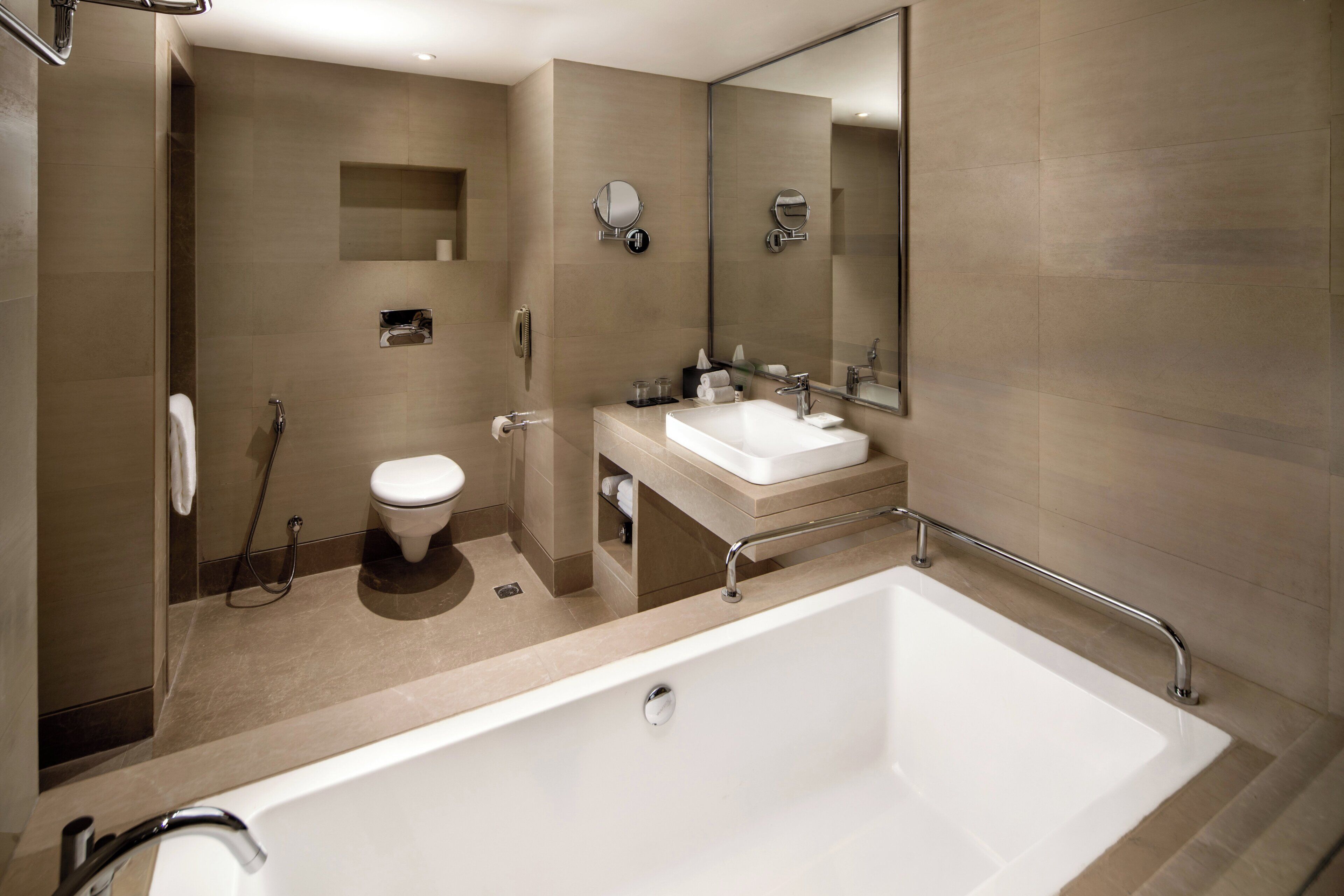 A modern bathroom with a bathtub, toilet, and sink.