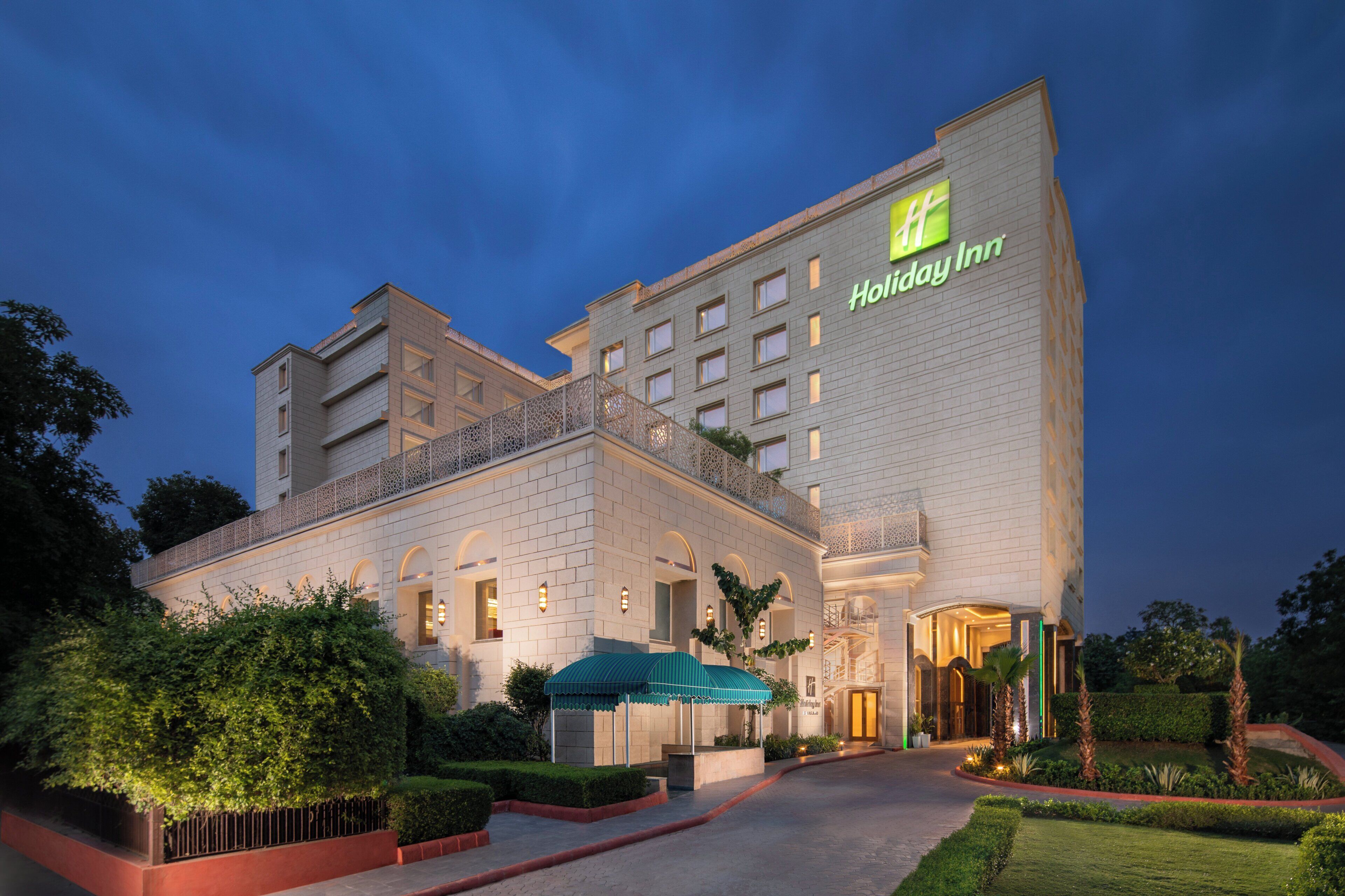 A Holiday Inn hotel with a modern facade, multiple balconies, and a well-lit entrance.