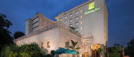 A Holiday Inn hotel with a modern facade, multiple balconies, and a well-lit entrance.