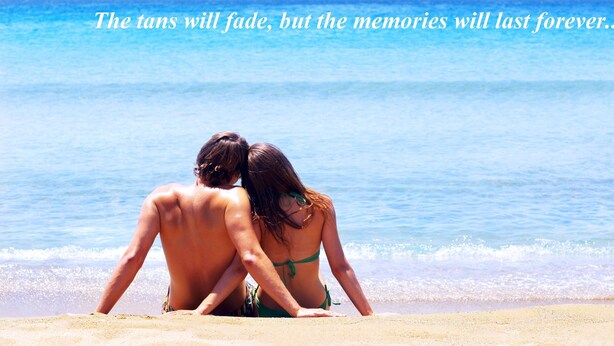 A couple sitting on a beach with the ocean in the background. - Vivian Studios (Rhodes)