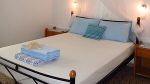 A bed with a canopy, two bedside lamps, a starfish decoration, and a folded towel on the bed. - Vivian Studios (Rhodes)