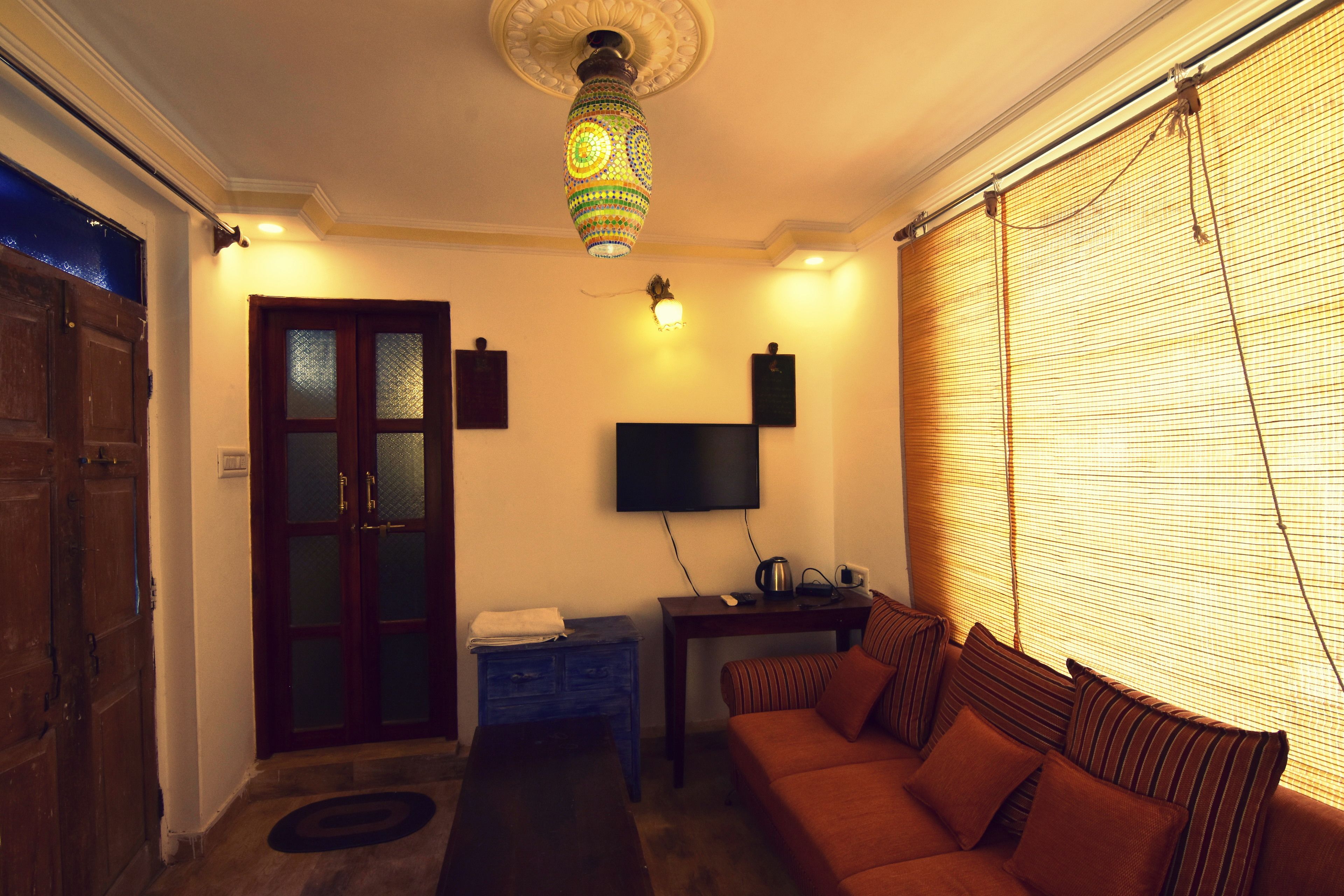 A living room with a sofa, a coffee table, a TV, and a decorative lamp.