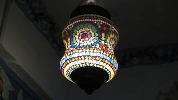 Una lámpara colgante con un diseño de mosaico, base oscura y motivos de estrellas coloridas.
