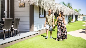 A couple walking towards a thatched-roof building with a sign reading "Village No. 2". - La Marina Resort (Elche)