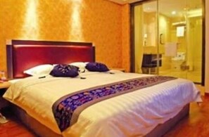 A hotel room with a large bed, a nightstand, and a glass door leading to a bathroom. - Home Club Hotel Yuexiu Branch (Guangzhou)