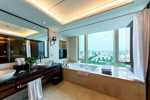 Un baño moderno con un lavamanos grande, una bañera y un ventanal con vistas a la ciudad.