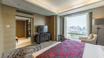 A hotel room with a large bed, a TV on a dresser, a city view, and a modern design.