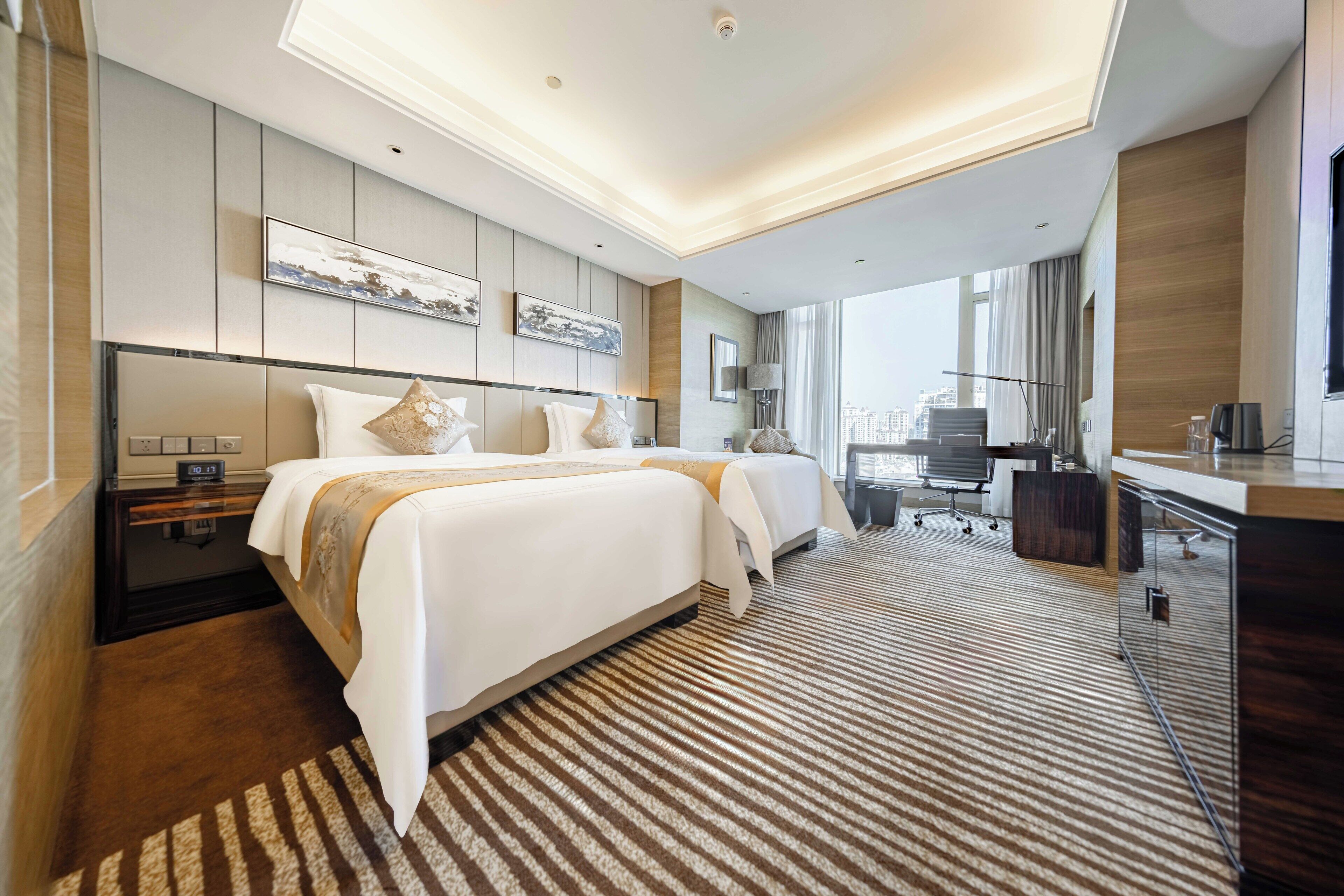 Una habitación de hotel moderna con una cama grande, un escritorio y vistas a la ciudad.