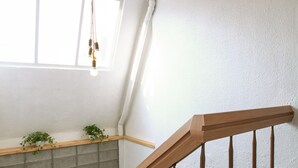 A staircase with wooden railings and a light fixture above. - Travel Monster (Seoul)