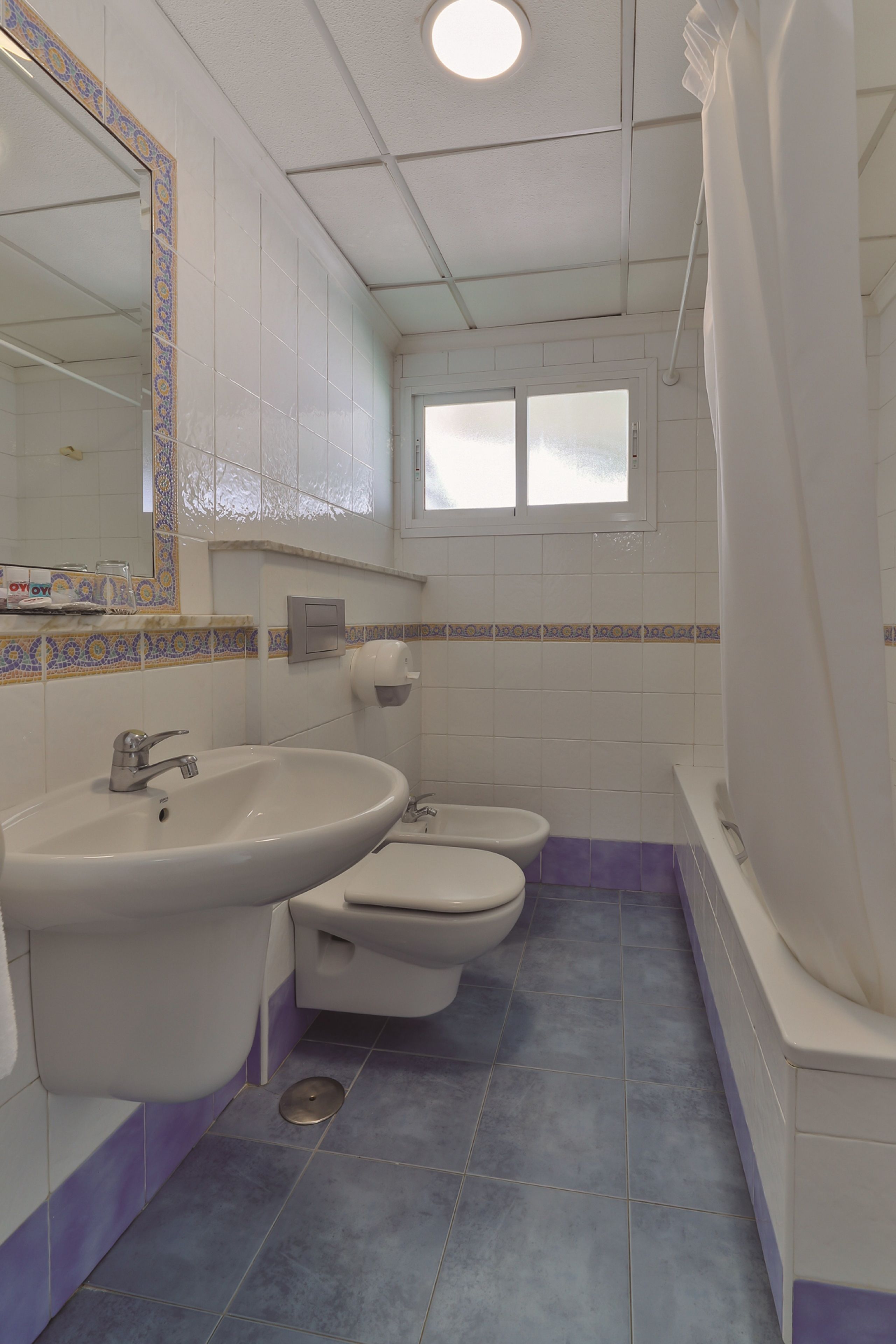 Un baño con lavamanos, inodoro y bañera.
