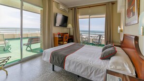 A hotel room with a bed, a television, a desk, and a balcony with a view of the sea. - Hotel Polamar  (Santa Pola)