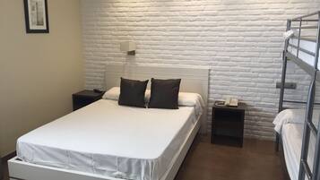 A single-bed room with a white headboard, two bedside tables, a white-framed bed, a white brick-patterned wall, a framed picture on the wall, and a bunk bed to the right.