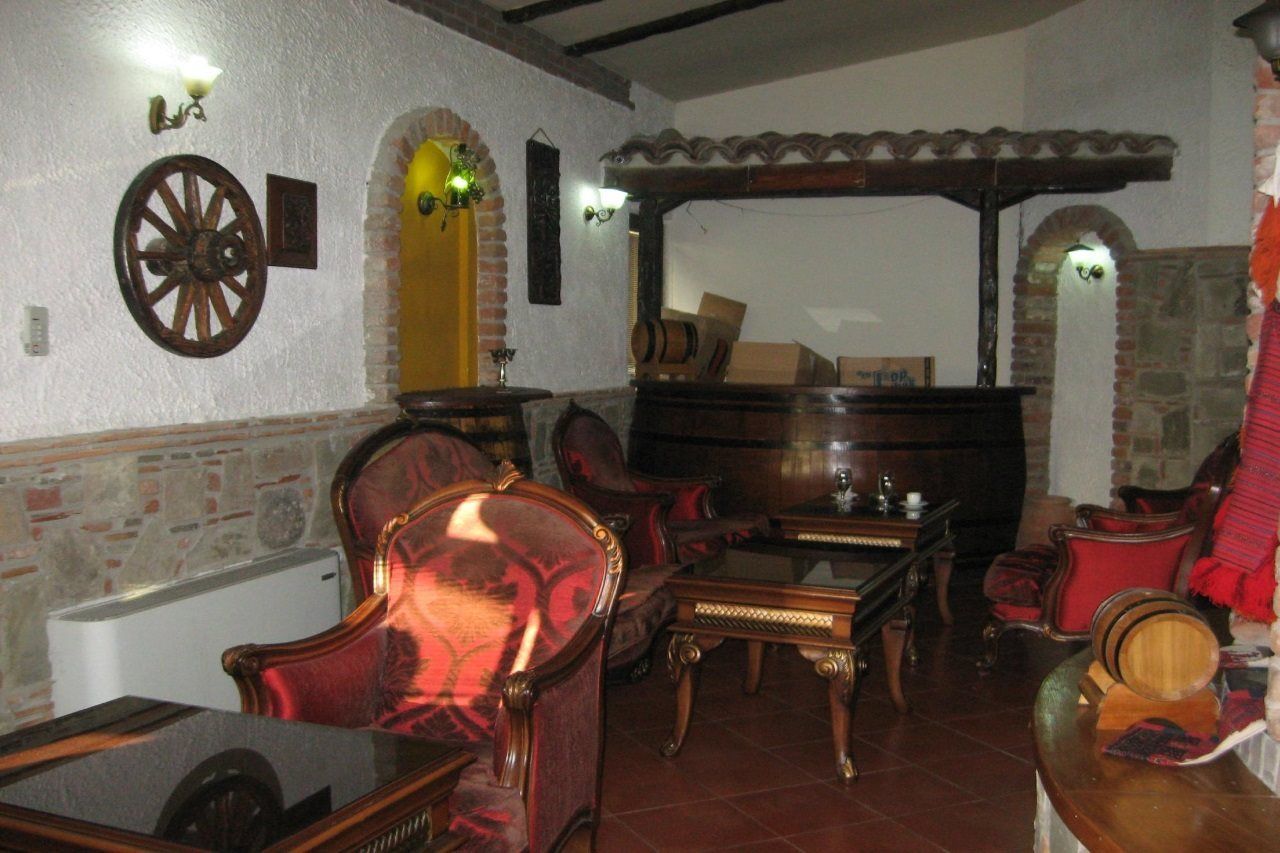 A room with a fireplace, wooden furniture, and a stone wall.