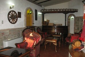 Una habitación con chimenea, muebles de madera y una pared de piedra.