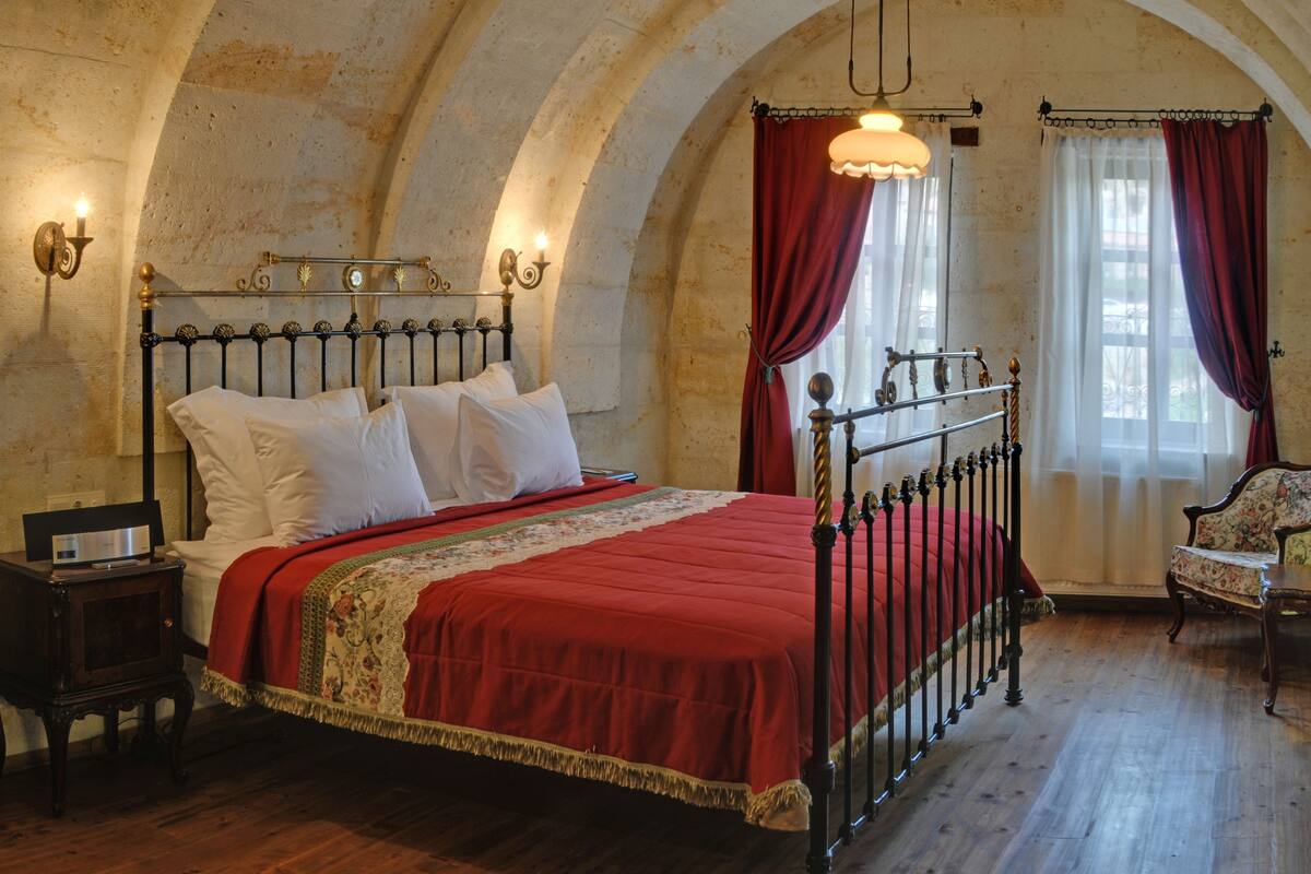 Una habitación con una cama, una silla y una mesita de noche.