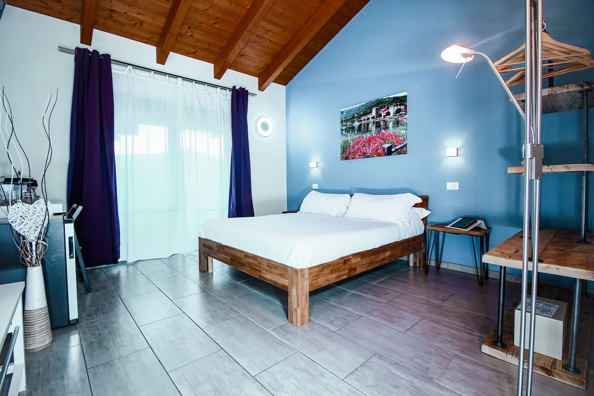 Um quarto com uma cama de madeira, uma escrivaninha e uma cadeira.