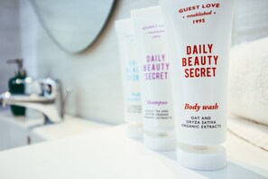 Three bottles of Daily Beauty Secret body wash on a bathroom counter.