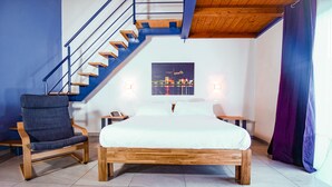 A bedroom with a wooden bed, a chair, a nightstand, and a staircase. - Agriturismo Il Cucchiaio di Legno (Orta San Giulio)