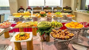 A buffet table with various food items and a welcome sign for the Denoro Hotel. - Dendro Hotel (Nha Trang)