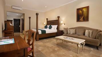 A hotel room with a bed, a sofa, a desk, and a coffee table.