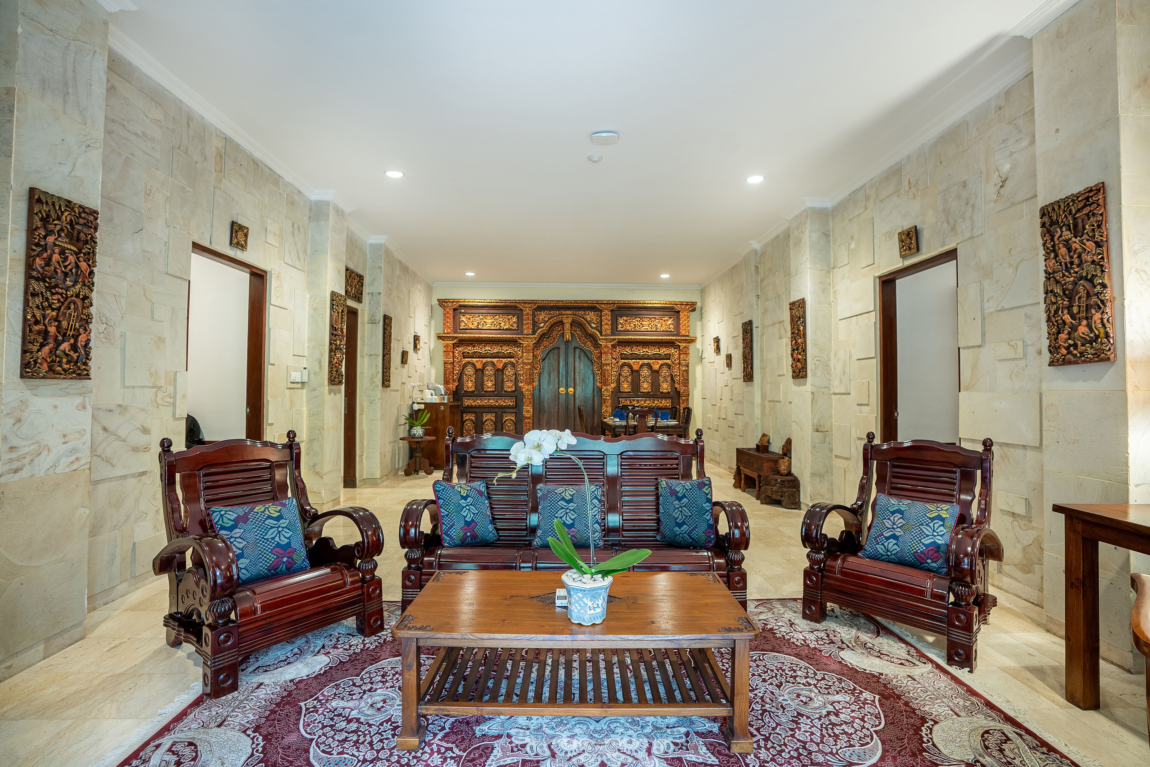 A spacious room with a large sofa set, a coffee table, and a patterned rug.