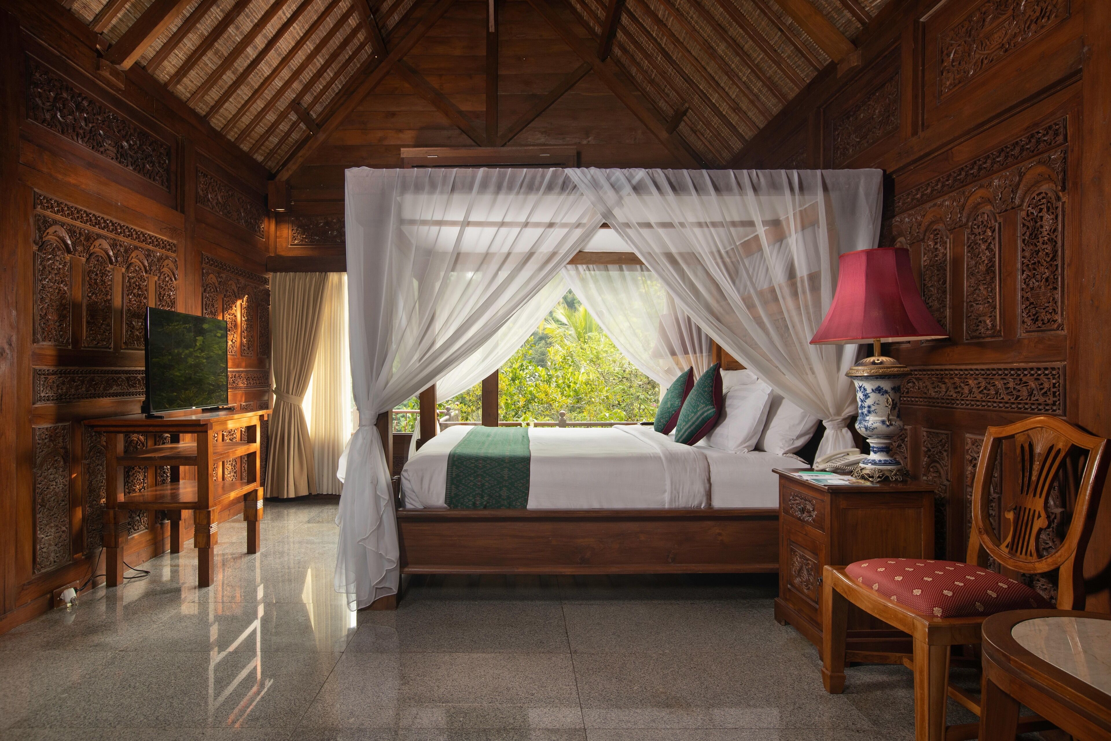 A wooden room with a bed, a desk, a chair, and a nightstand.