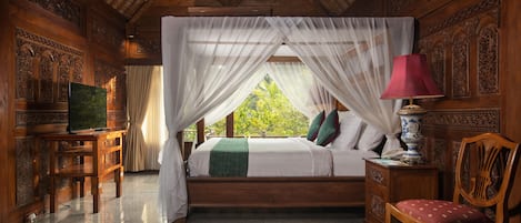 A wooden room with a bed, a desk, a chair, and a nightstand.