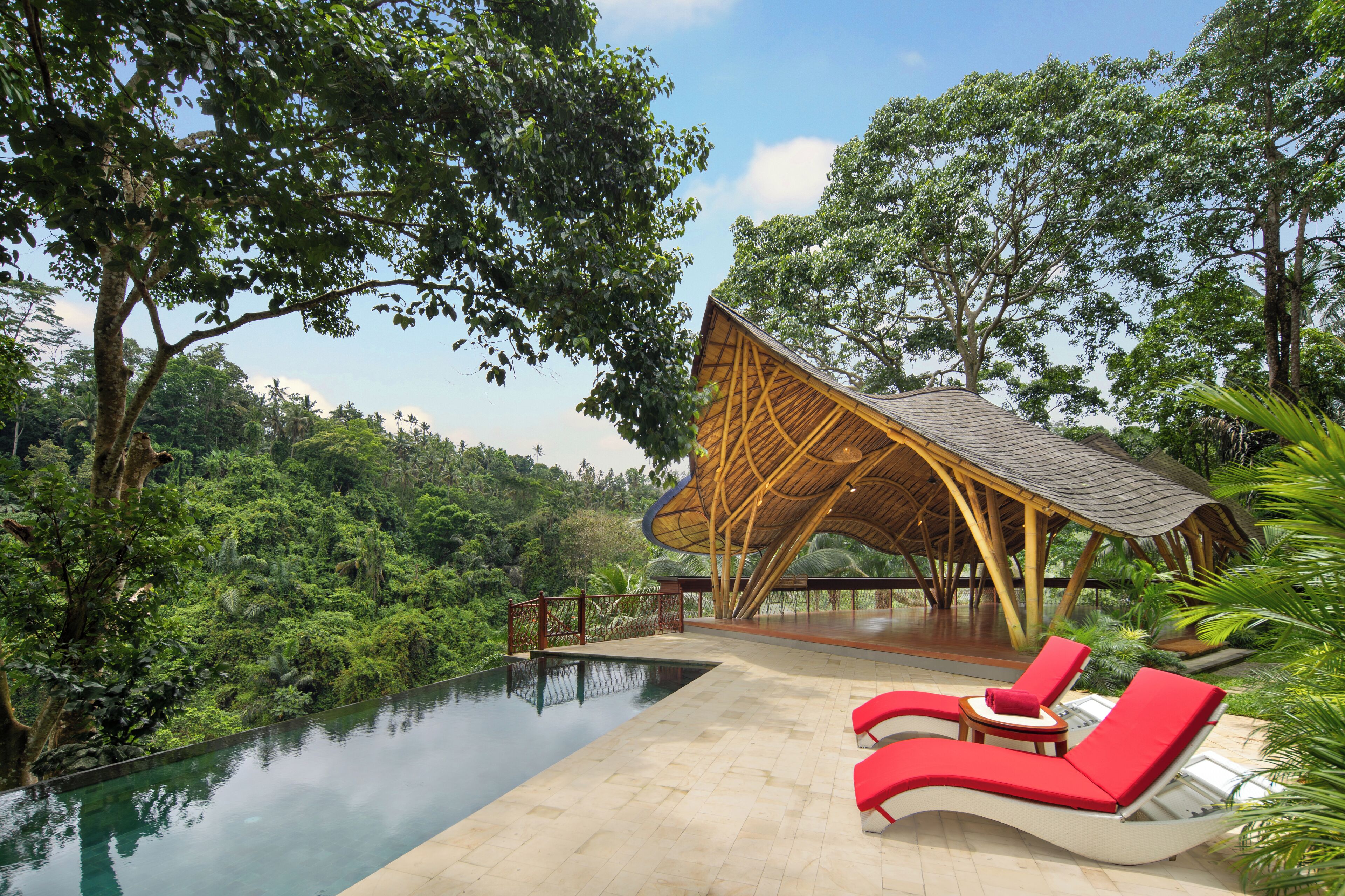 A poolside area with lounge chairs and a wooden structure.