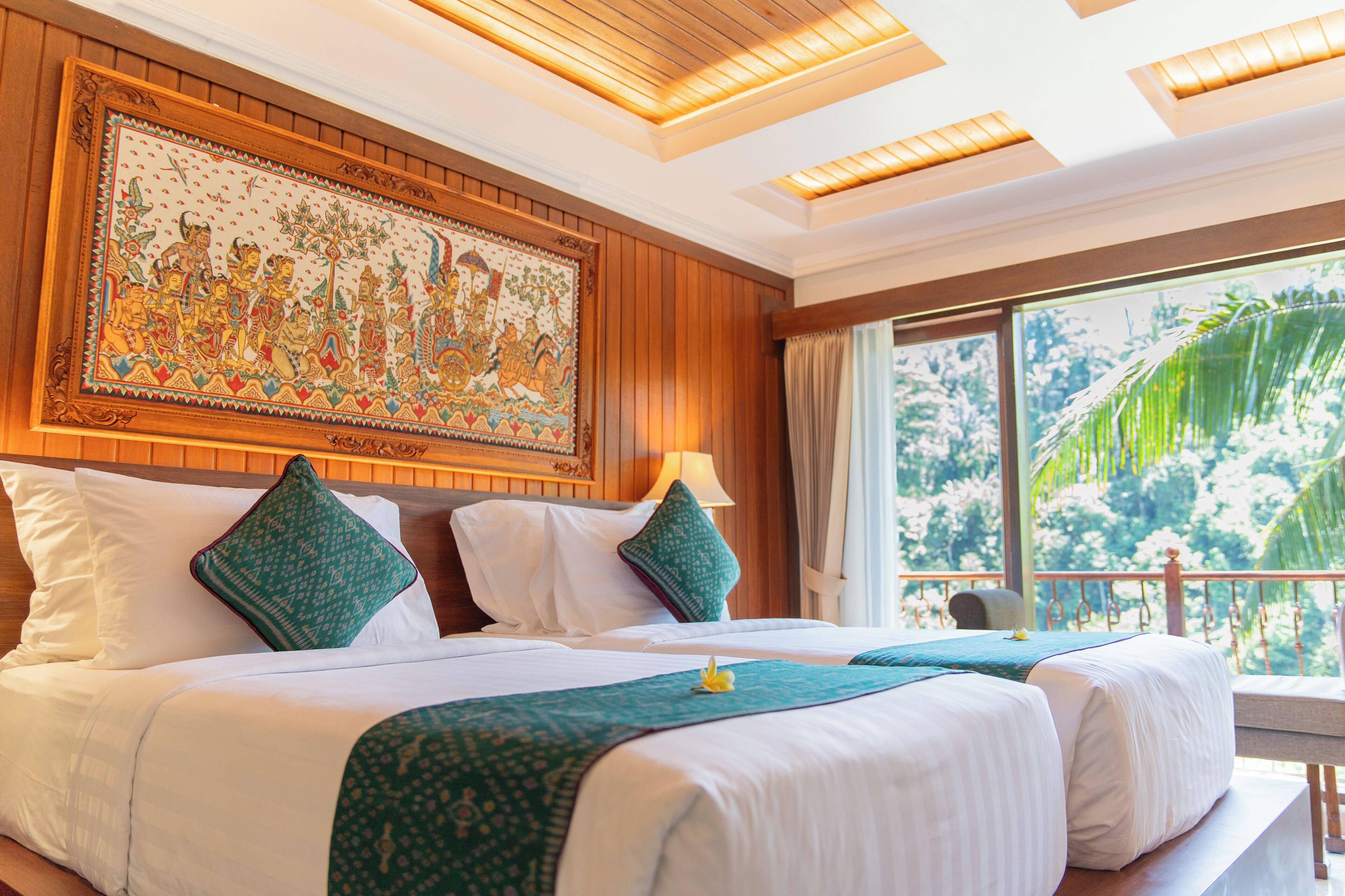 A hotel room with two beds, a large mural on the wall, and a view of the outdoors.