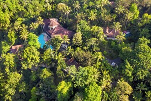 An aerial view of a tropical resort with multiple buildings surrounded by dense palm trees. - Ayung Resort Ubud (Ubud)