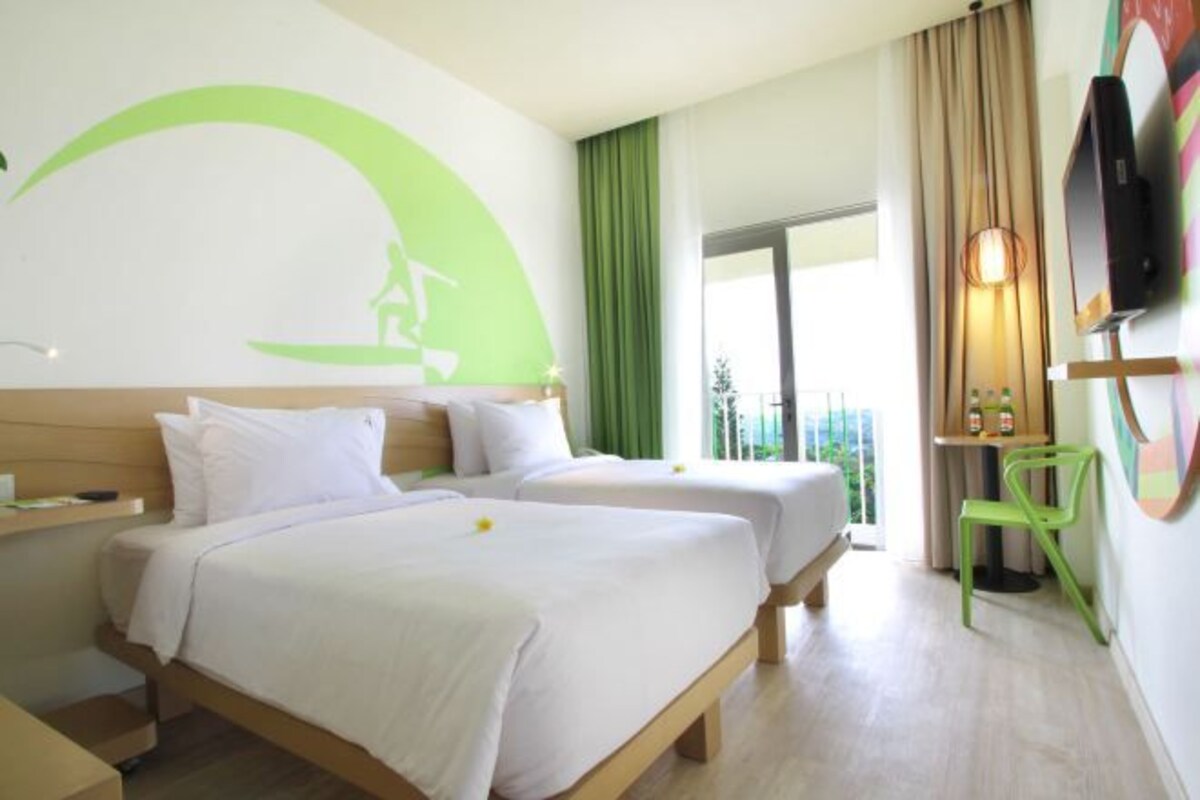 Een hotelkamer met twee bedden, een televisie, een bureau en een balkon met uitzicht.