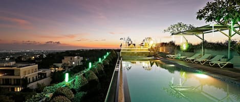 Una piscina al aire libre, sombrillas, tumbonas