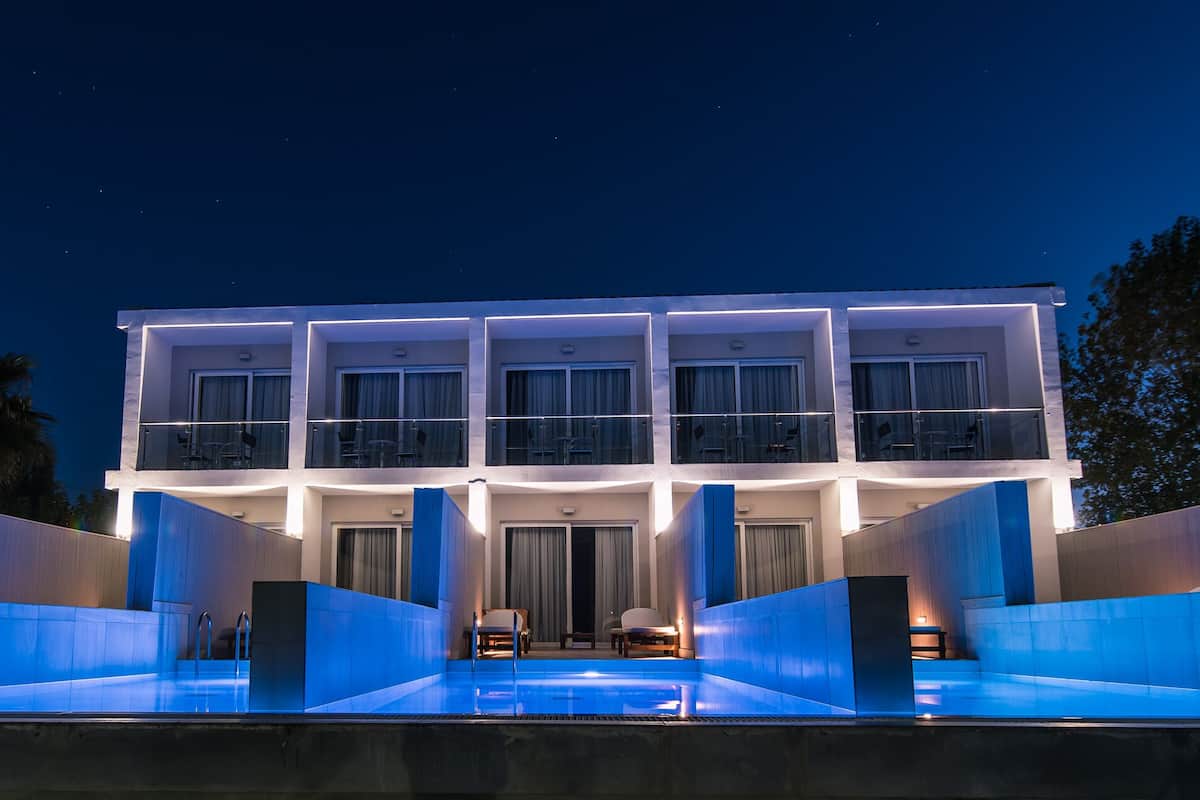 Un hôtel moderne doté d’une piscine, de nombreux balcons et d’une façade bien éclairée.