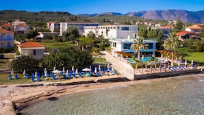 Un hôtel situé sur la côte, doté d’une piscine, d’un espace de détente en bord de mer et offrant une vue sur les montagnes.