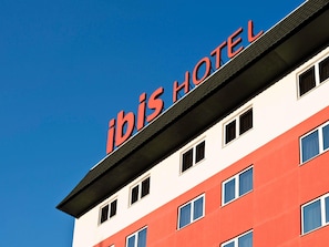 A hotel sign with the name 'ibis HOTEL' on a building.