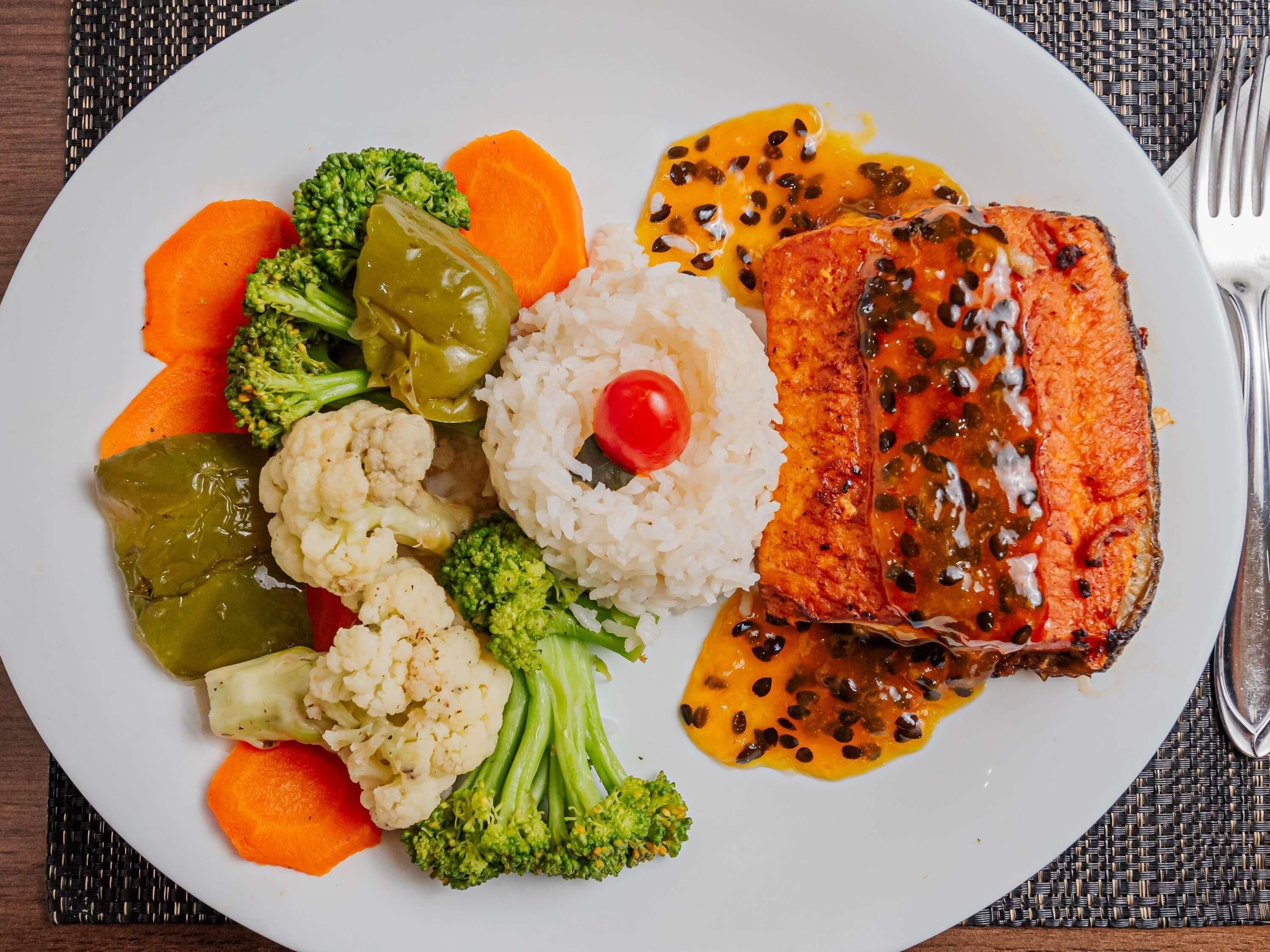 A plate with salmon, rice, and mixed vegetables.