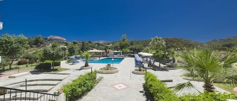 Piscine extérieure, parasols de plage, chaises longues