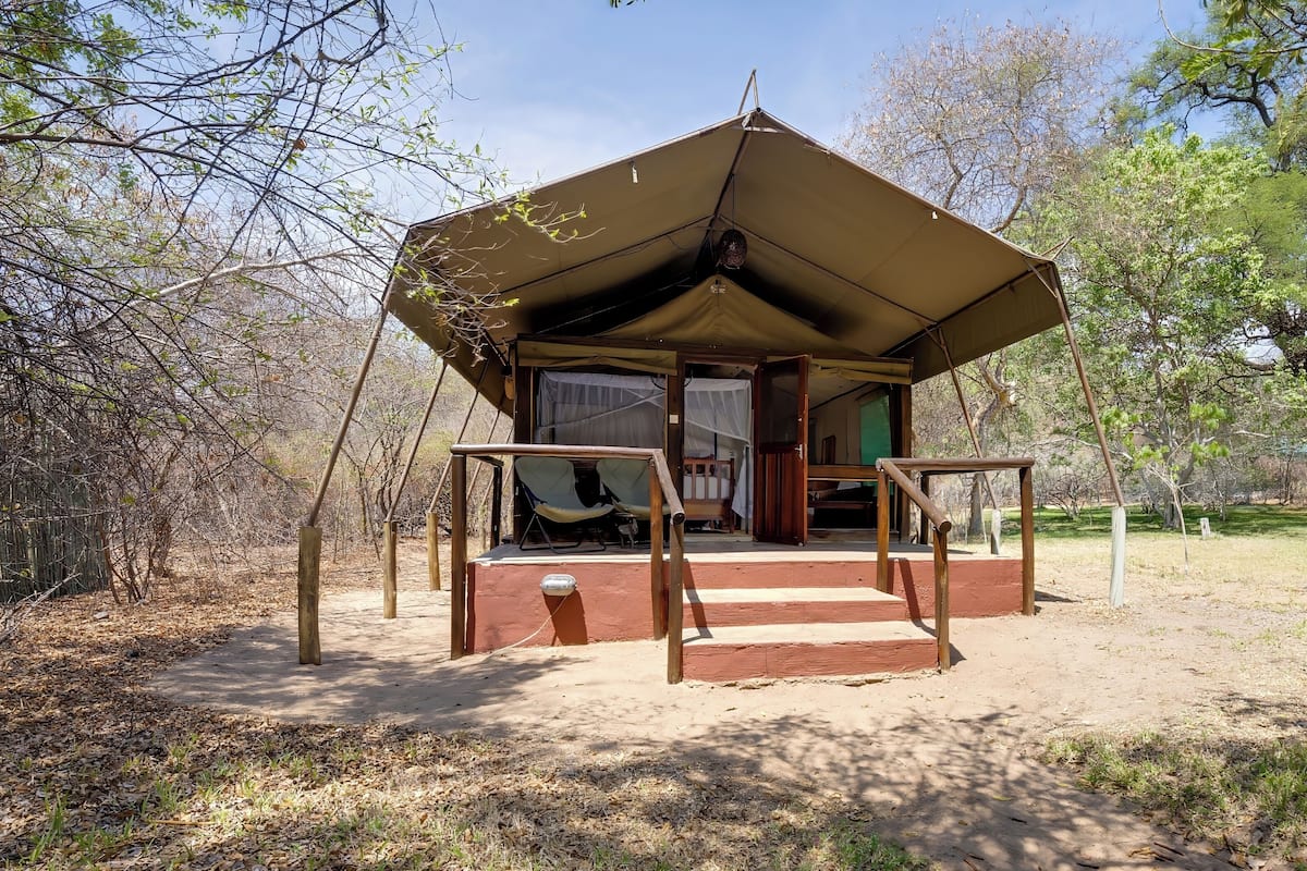 Una estructura pequeña y al aire libre con techo inclinado, barandillas de madera y una entrada sencilla.