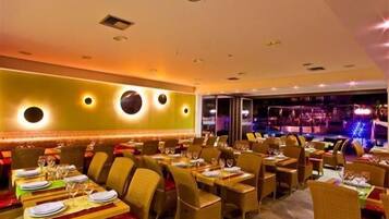 Ein Restaurant mit mehreren Tischen, Stühlen und einer Bar.