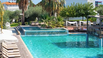 Una piscina al aire libre de temporada, sombrillas