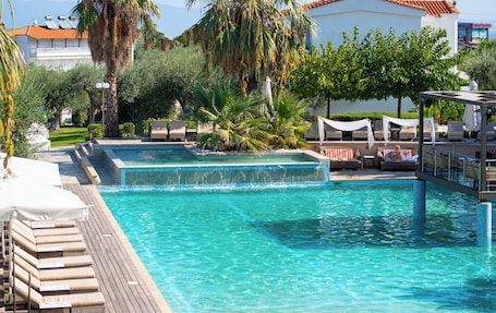 Una piscina al aire libre de temporada, sombrillas