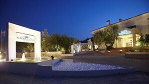 A hotel entrance with a sign for 'FLEGRIA PALACE' and 'HOTEL DE LA PALACE' illuminated at dusk. - Flegra Palace (Kassandra)