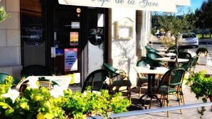 An outdoor café with a sign reading "Café de la Gare," featuring outdoor seating and potted plants. - Hôtel Belle Epoque (Chinon)