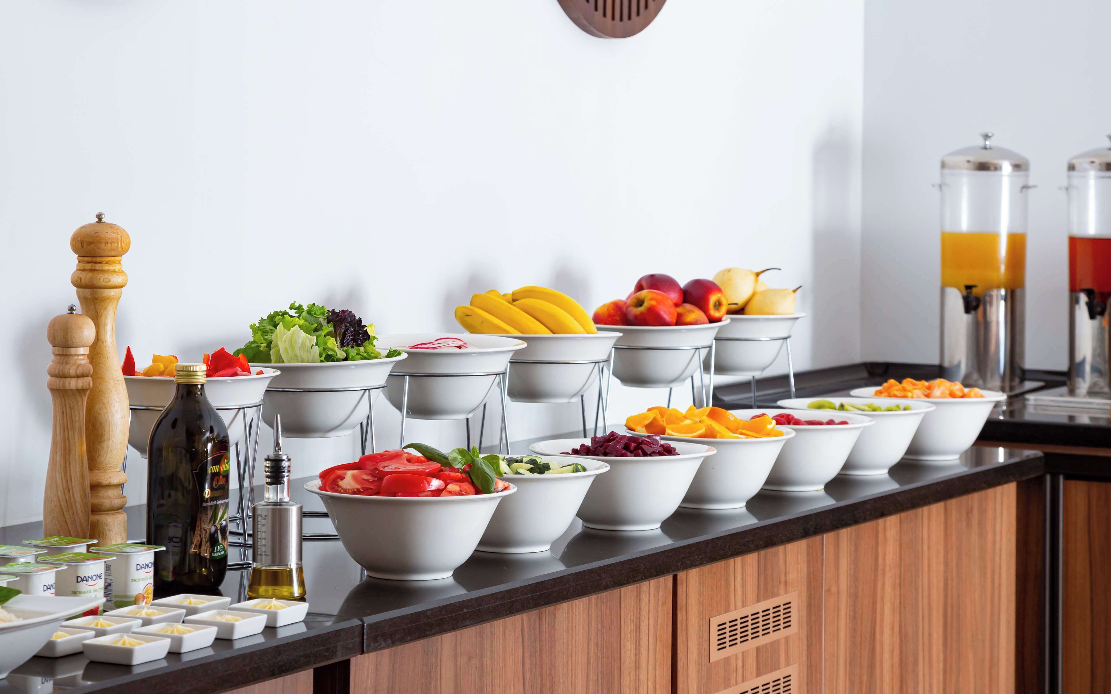 A buffet setup with various food items and condiments.