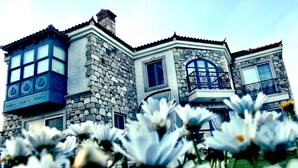 A stone building with multiple windows and balconies. - Alaçatı Sultan Konak Butik Otel (Cesme)