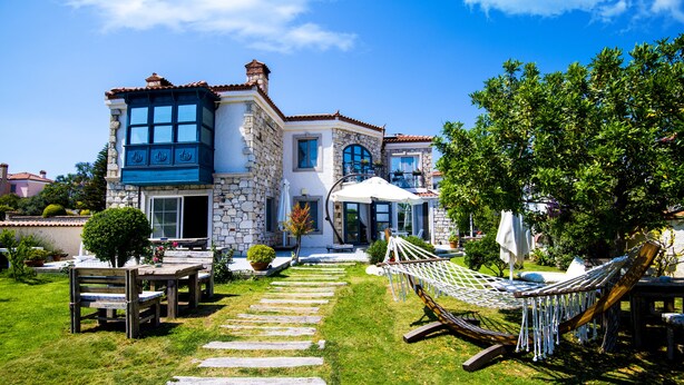 A stone house with a garden, a hammock, and a stone pathway. - Alaçatı Sultan Konak Butik Otel (Cesme)