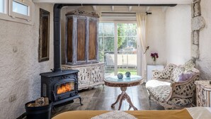A cozy room with a fireplace, a sofa, and a table. - Alaçatı Sultan Konak Butik Otel (Cesme)
